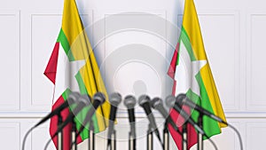 Myanma official press conference. Flags of Myanmar and microphones. Conceptual 3D rendering