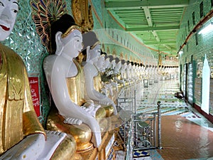 Myanmar, Sagaing Hill, Pagoda U Min Thonze with gilded Buddha images seated in crescent-shaped colonnade