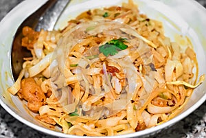 Myanmar traditional or classic white flat noodle salad called Khauk Swe Thoke in white bowl