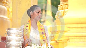 Myanmar women holding flowers at a temple. Southeast Asian young girls with burmese traditional dress visiting a Buddihist temple.