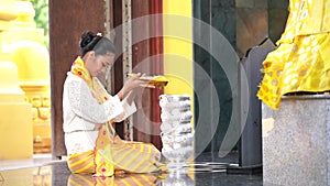 Myanmar women paying their respects at a temple. Southeast Asian young girls with burmese traditional dress visiting a Buddihist t