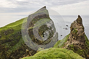 Mykines green cliffs on Faroe islands. Hiking landmark