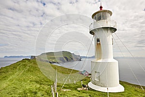 Mykines lighthouse and cliffs on Faroe islands. Hiking landmark