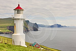 Mykines lighthouse and cliffs on Faroe islands. Hiking landmark