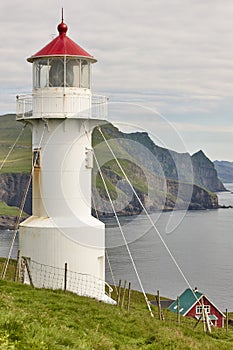 Mykines lighthouse and cliffs on Faroe islands. Hiking landmark