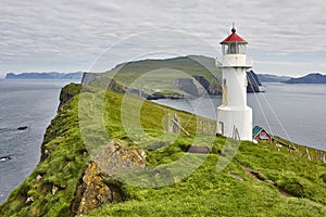 Mykines lighthouse and cliffs on Faroe islands. Hiking landmark