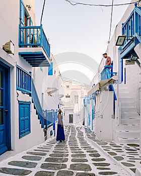Mykonos Greece, Young man and woman in dress at the Streets of old town Mikonos during vacation in Greece, Little Venice