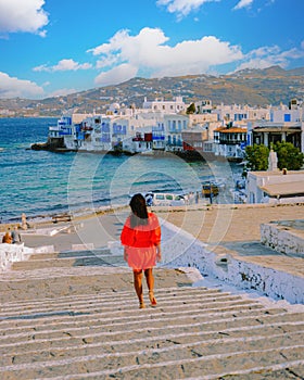 Mykonos Greece, Young woman in dress at the Streets of old town Mikonos during vacation in Greece