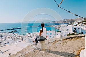 Mykonos Greece, Young woman in dress at the Streets of old town Mikonos during vacation in Greece, Little Venice Mykonos