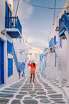 Mykonos Greece, Young woman in dress at the Streets of old town Mikonos during vacation in Greece, Little Venice Mykonos