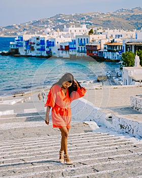 Mykonos Greece, Young woman in dress at the Streets of old town Mikonos during vacation in Greece photo