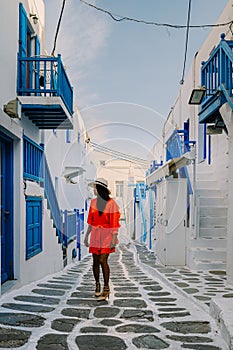 Mykonos Greece, Young woman in dress at the Streets of old town Mikonos during vacation in Greece, Little Venice Mykonos photo