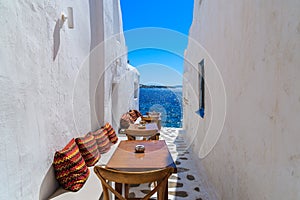 Benches with pillows in a typical Greek bar in Mykonos town with sea view, Cyclades islands, Greece