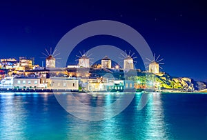 Mykonos port with boats and windmills at evening, Cyclades islands.