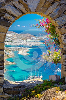 Mykonos port with boats and windmills at evening, Cyclades islands.