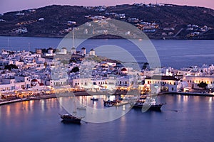 Mykonos port with boats and windmills at evening, Cyclades islands.