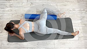 Myofascial relaxation with a foam roller during fitness training. Rolling the fasciae of the inner surface of the thigh.