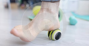 Myofascial relaxation of foot muscles with massage ball on gymnastic mat