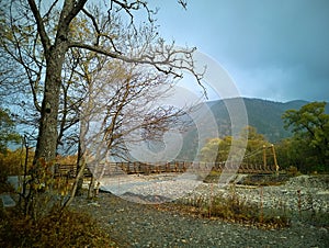 Myojin bridge and Azusa river in late autumn at Kamikochi National Park, Matsumoto, Nagano, Japan