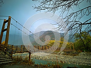 Myojin bridge and Azusa river in late autumn at Kamikochi National Park, Matsumoto, Nagano, Japan