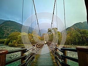 Myojin bridge and Azusa river in late autumn at Kamikochi National Park, Matsumoto, Nagano, Japan