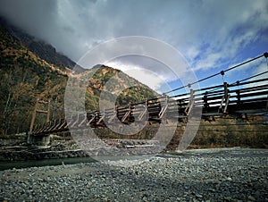 Myojin bridge and Azusa river in late autumn at Kamikochi National Park, Matsumoto, Nagano, Japan