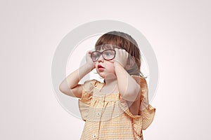 Myopia in children. Portrait of beautiful little girl wearing glasses on grey background. Vision, health, ophthalmology