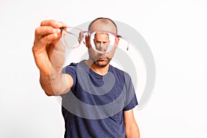 Myopia in mature men is corrected with glasses, a young man holds glasses in his hand photo