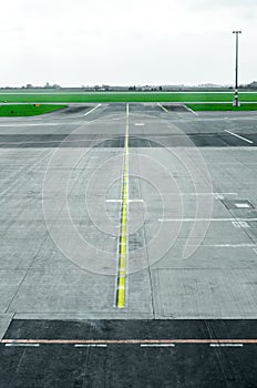 Myst on empty airport runway tarmac with directional and markings sign