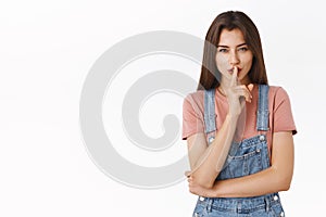 Mysterious alluring modern brunette woman in overalls, t-shirt, prepare surprise asking keep quiet about her secret