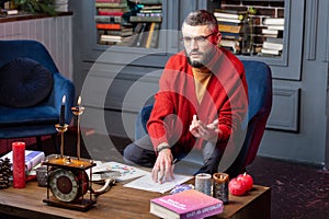 Mysterious astrologist making some notes while studying astrology photo