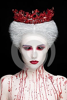 Mysterious beauty portrait of snow queen covered with blood. Bright luxury makeup. Black demon eyes.