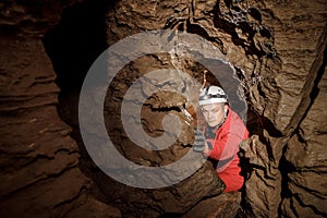 Mysterious deep dark, explorer discovering mystery moody tunnel looking on rock wall inside.