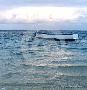 Mysterious, empty lone rowing boat at sea under blue sky