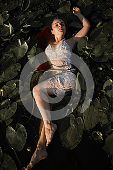 Mysterious And Fashion Portrait Of Young Woman Lying In Water