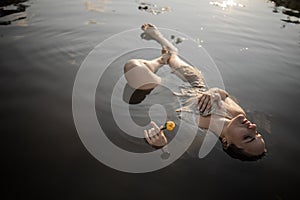 Mysterious And Fashion Portrait Of Young Woman Lying In Water