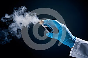 Mysterious hand holds vial releasing vapor in blue glove on dark background photo