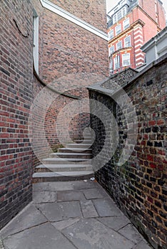 A mysterious and hidden old back alley with staircase in London at night