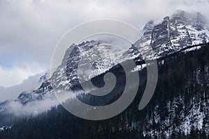 Mysterious landscape with mountains shrouded in fog and clouds in the winter. Shot in the Austrian Alps near the town of