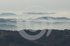 a mysterious landscape of mountains shrouded in fog and towering over the Mummelsee in Germany