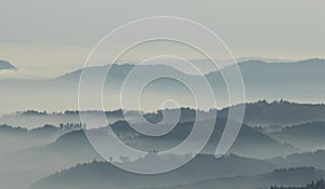 A mysterious landscape of mountains shrouded in fog and towering over the Mummelsee in Germany