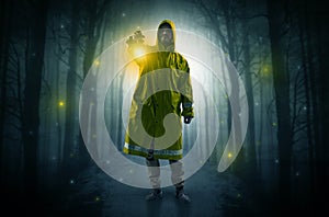 Mysterious man coming from a path in the forest with glowing lantern concept