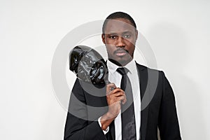 African young man wearing black suit taking off plastic mask revealing face