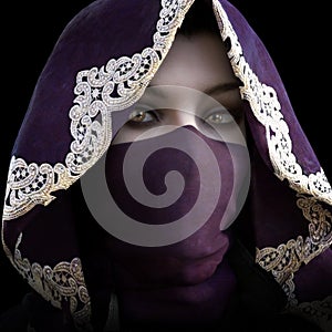 Mysterious masked hooded female staring at the camera