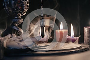 Mysterious Occult Ceremony with Pendulum and Mystic Symbols.