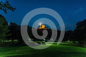 Mysterious Pilgrimage church of Maria of Strassengel in the moonlight in background of a green field