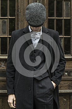 Mysterious portrait of retro 1920s english gangster with flat cap.