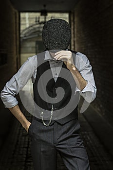 Mysterious portrait of retro 1920s english gangster with flat cap.