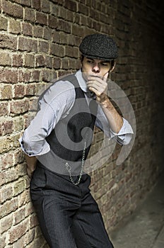 Mysterious portrait of retro 1920s english gangster with flat cap.