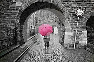 Mysterious pretty scene and woman behind an umbrella black and white colorsplash pink umbrella.In maastricht holland